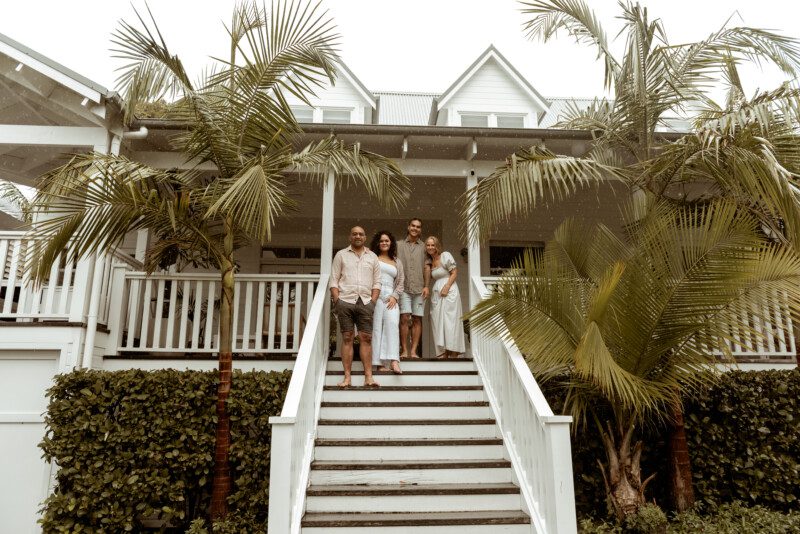 An Aloca host with their family in front of their home